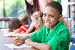 school boy smiling at desk